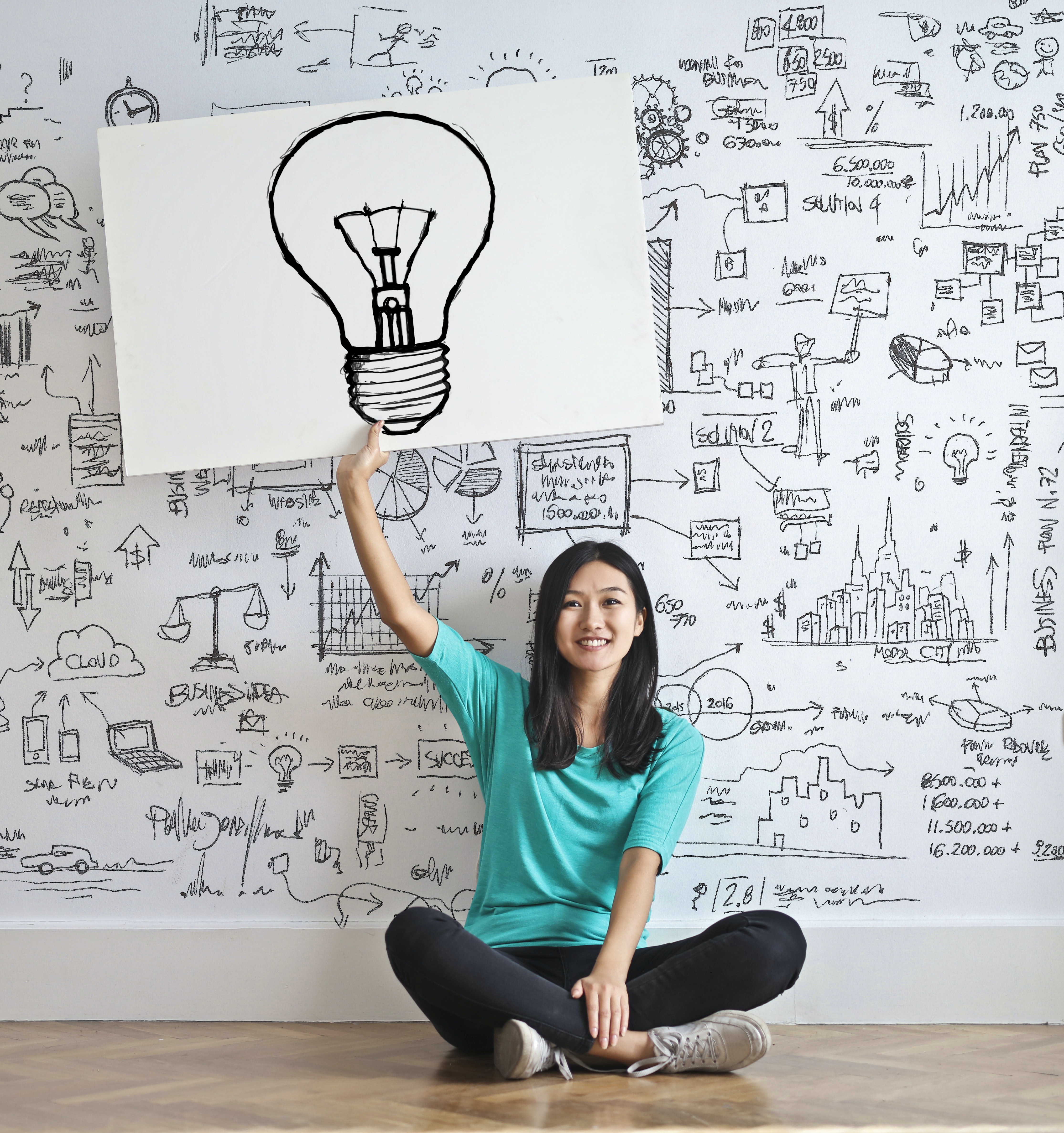 Woman holding poster with lightbulb on it